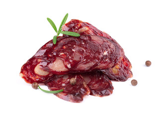 Horse sausage slice with rosemary and pepper. Tasty dried sausage, close-up, isolated on white background.