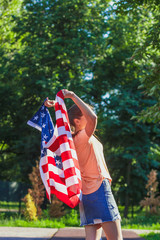 Woman with a flag of United States of America in the hands, outdoors