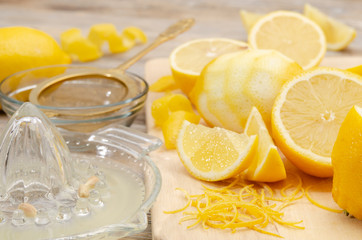Zitronensaft in Zitronenpresse und Zitronenschale
