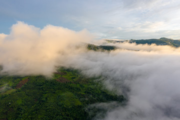 Aerial top view of the moving flow of the mist or foggy in between the hills of mountains