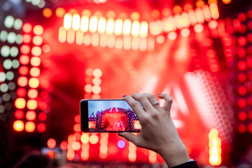 Hand with a smartphone records live music festival, live concert, live concert
