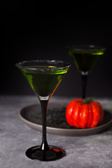 Two glasses with green zombie cocktail for Halloween party on the dark background