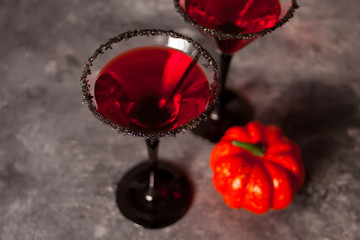 Two glasses with red cocktail for Halloween party on the dark background