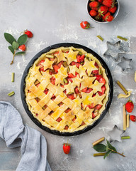 American traditional pie with strawberries and rhubarb on a gray concrete background. Pie with the stars)