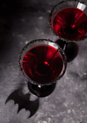 Two glasses with red cocktail for Halloween party on the dark background