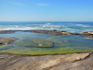 praia pedras no fundo