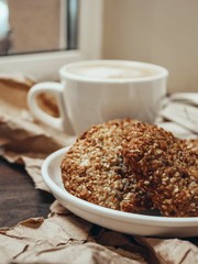 cup of coffee with cookies near the window