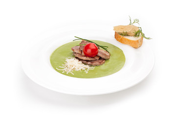 Spinach puree soup with meat fillets medallions and canape.