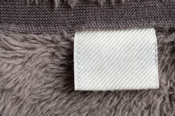 Blank white laundry care clothing label on fur texture background