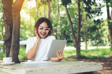 Fototapeta premium A happy businesswoman because she saw the profits shown in her tablet.