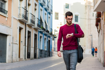 Young businessman is walking on the street with his backpack