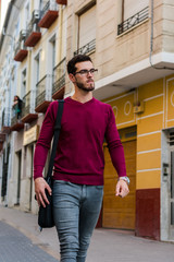 Young businessman is walking on the street with his backpack