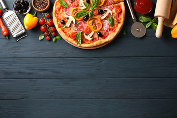 Delicious pizza and ingredients on wooden background, copy space
