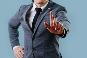 Businessman in suit making objection gesture , holding index finger up over blue - obrazy, fototapety, plakaty