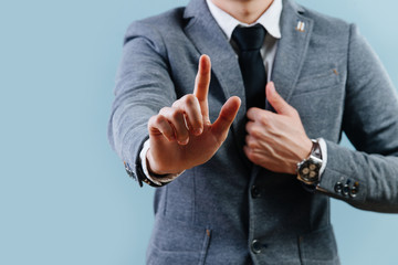 Businessman in suit making objection gesture , holding index finger up over blue