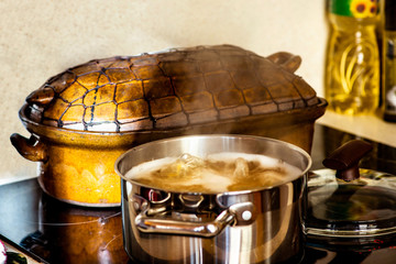 Pot with boiling water, old rustic pan, oil.