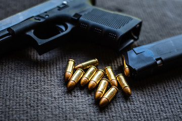 bullets and gun on black velvet desk