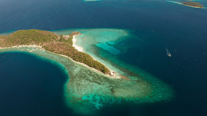 Naklejka na ściany i meble Aerial drone Island in blue lagoon with sandy beach and coral reef. Malcapuya, Philippines, Palawan. Tropical landscape with blue lagoon, coral reef