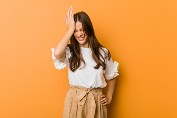 Young caucasian woman forgetting something, slapping forehead with palm and closing eyes.