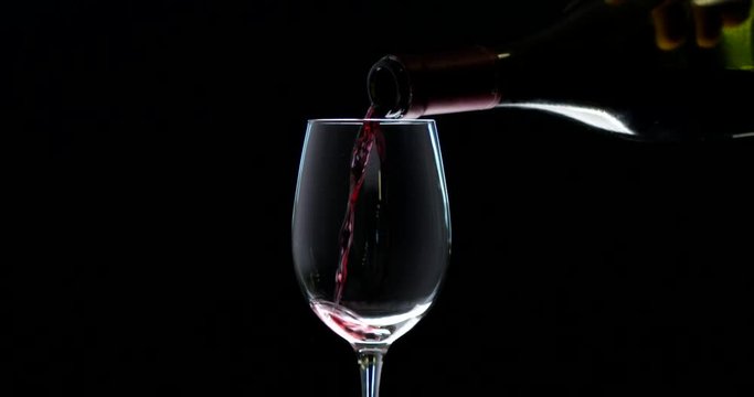 Slow motion of wine spilling in front of a black background. RED camera