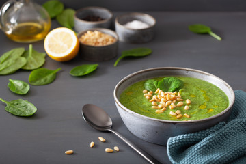 green creamy cauliflower spinach soup on gray background