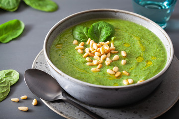 green creamy cauliflower spinach soup on gray background