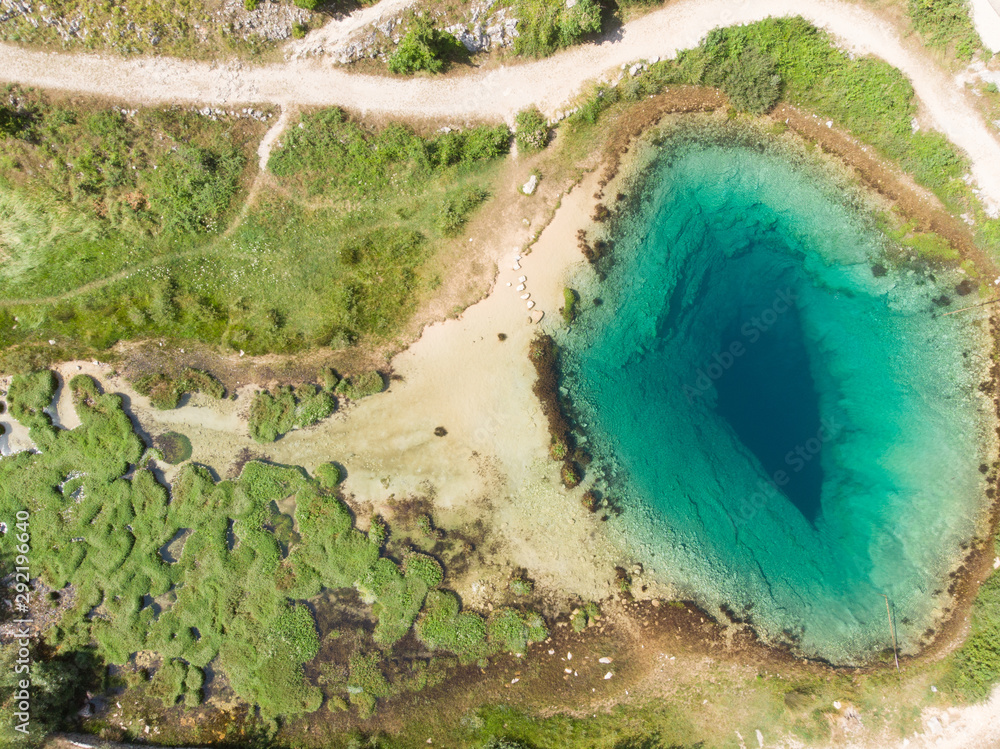 Poster The cave spring of the Cetina River (izvor Cetine) in the foothills of the Dinara Mountain is named Blue Eye (Modro oko). Cristal clear waters emerge on the surface from a more than 100 m deep cave