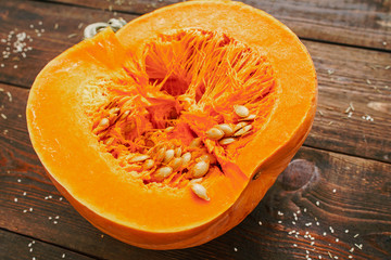 Healthy diet. Fall seasonal organic fruit. Orange pumpkin half on wooden table.