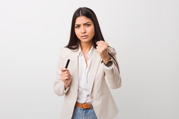 Fototapeta premium Young arab woman holding a credit card showing fist to camera, aggressive facial expression.