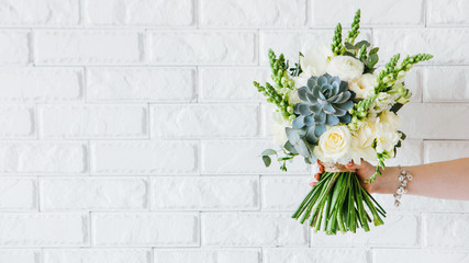 Flower gift. Holiday greeting congratulation. Female hand holding roses succulent bouquet.