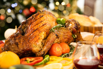 Roasted  chicken or turkey with sauce and grilled autumn vegetables: corn,pumpkin  on wooden table, top view, frame. Christmas or Thanksgiving Day food concept.