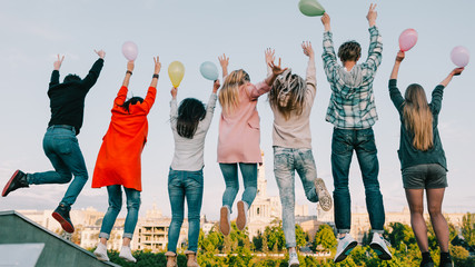 Roof party. Teen joy happiness entertainment. Friends with balloons having fun jumping.