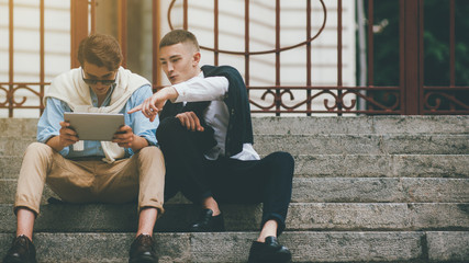 Modern leisure. Social communication. Male friends watching entertaining content online on tablet.