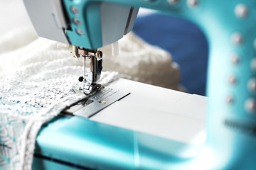 Sewing machine with denim and thread for sewing, close-up. The working process. Part of a sewing machine with blue cloth.