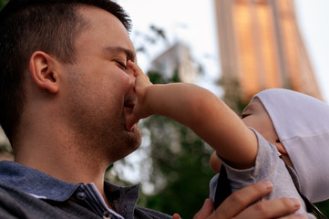 Father and one year old son against the sky and skyscrapers. Travel with children, the development of emotional intelligence. Early development.