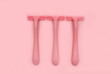 Three pink woman shaver isolated on pink paper background. Copy space, place for text. Flat lay. Shaving concept.