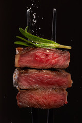 Steak concept. Closeup beef steak cuts piece slice medium well rare with rosemary and falling salt...