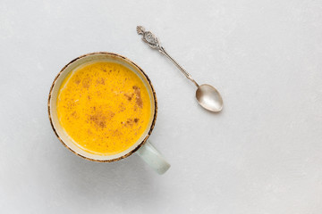 Turmeric latte with milk and cinnamon. Elixir of health and vivacity. Traditional healthy Indian...