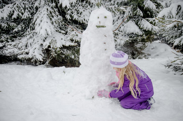 child, snowman and winter forest