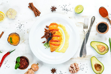 Chicken fillet baked with tomatoes. In the plate. On a wooden background. Top view. Free space for your text.