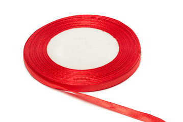 Spool of bobbin with red ribbon for wrapping gifts isolated on white background