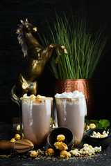 Cocoa with milk and popcorn. In the glass. Top view. On a black background.