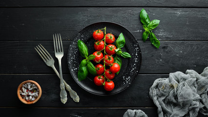 Cherry tomatoes and basil in the plate. Top view. Free space for your text.