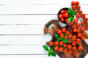 Cherry tomatoes on a white wooden background. Top view. Free space for your text.