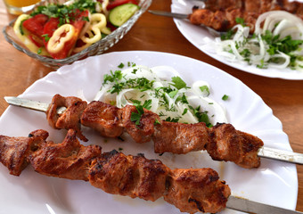 Grilled meat on a skewers lies on a plate