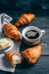 croissants and coffee on dark wooden table