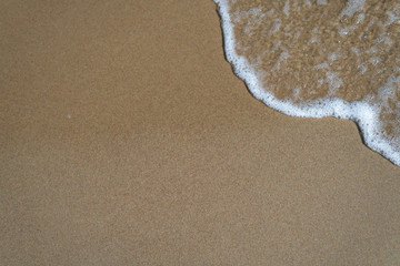 Beautiful waves rolling up on a sandy beach. Summertime in Österlen, Sweden.