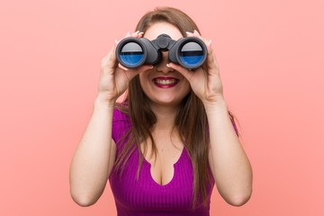 Young caucasian woman looking through binoculars