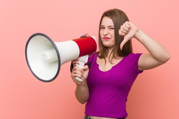 Young caucasian woman speaking through a megaphone