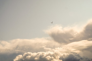 The sun and clouds on the blue sky. Cloudy weather with cumulus, dark clouds. Autumn day. A strong wind blows, the pressure is low, the threshold of rain.